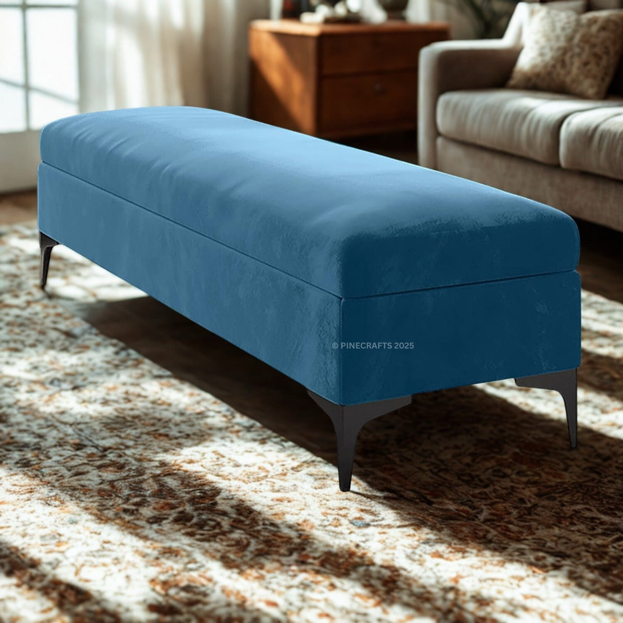 Blue storage bench in a living room setting with sunlight filtering through curtains.